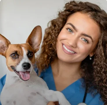 Veterinária sorrindo ao lado de um cão